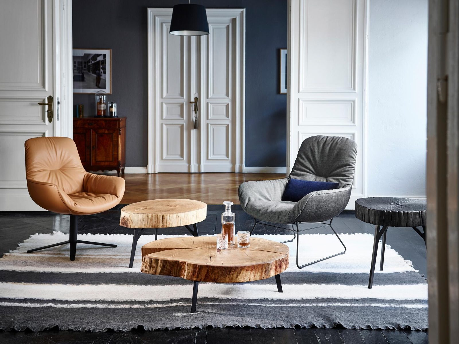 Freifrau Leya Lounge Chairs in Cognac-Leder und Grau mit Baumscheiben-Tischen in einem Altbau